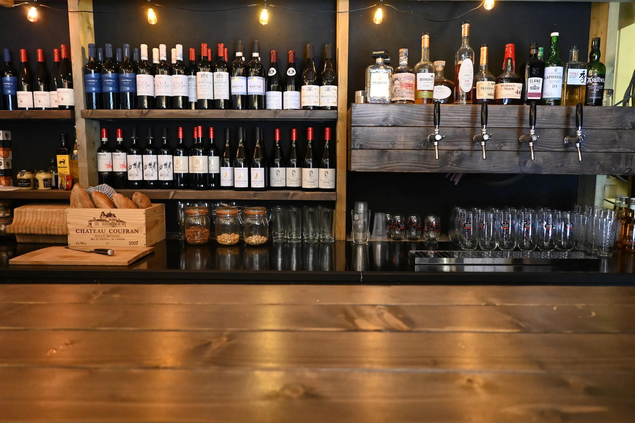 Bar interior, wine bottles and beer taps behind bar.